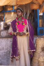 Woman in traditional anarkali with jewelry standing in a market setting
