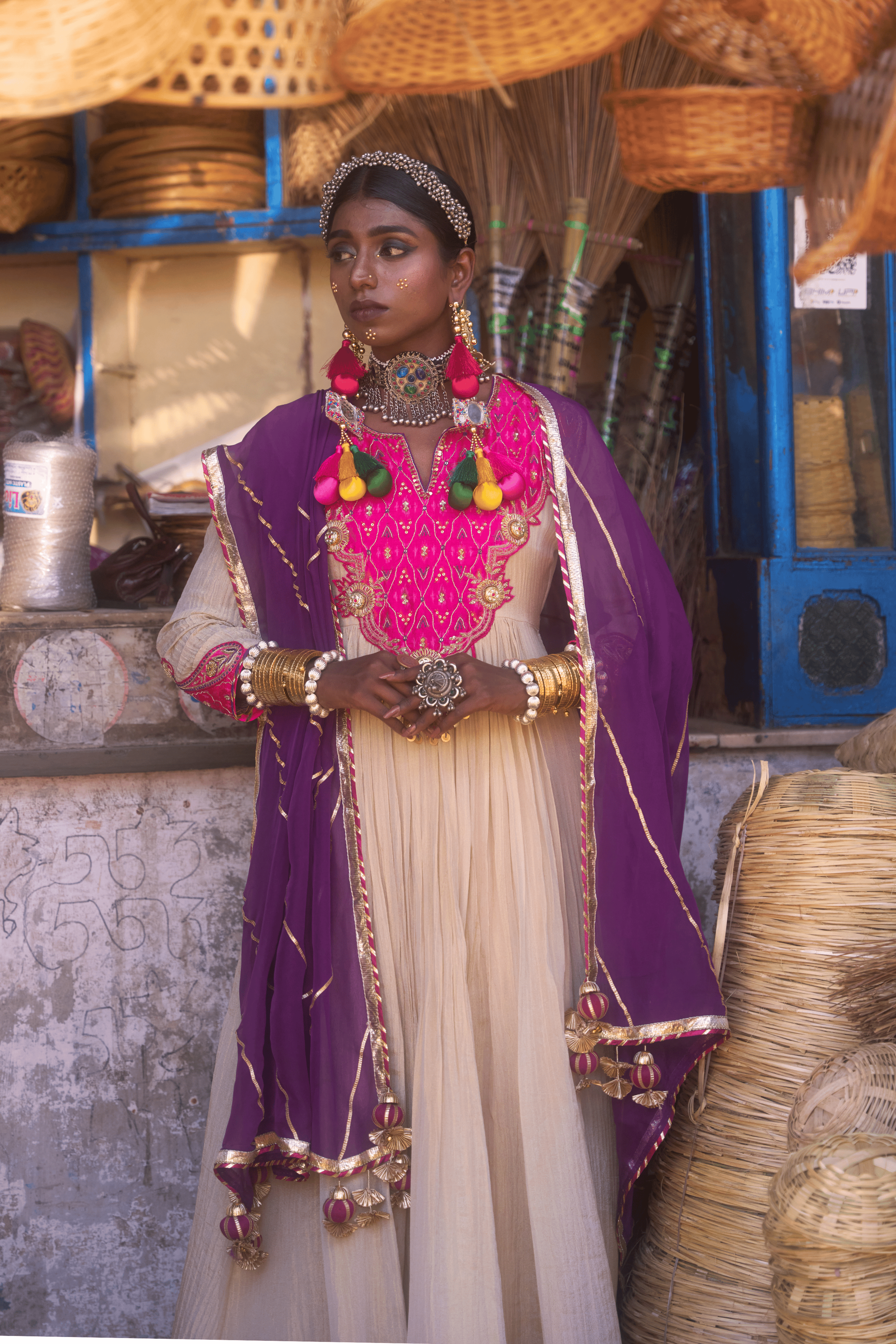 Woman in traditional anarkali with jewelry standing in a market setting
